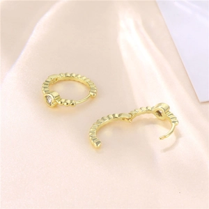 Elegant gold heart earrings with sparkling cubic zirconia on a smooth silk background