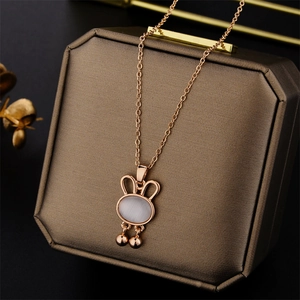 Rose gold rabbit necklace with white opal stone and bells on a luxury display box