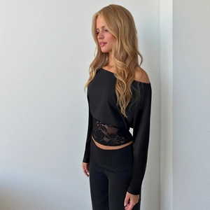 Close-up of elegant black lace patchwork on off-shoulder top with satin texture finish