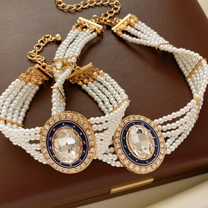 Detail of multi-layer pearl bracelets with blue enamel and sparkling rhinestones