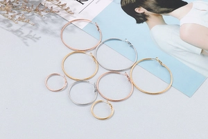 Detail of twisted metal hoop earrings in gold, silver, and rose gold with various sizes