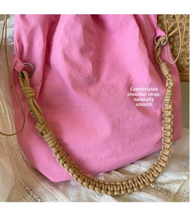 Dettaglio borsa a secchiello in nylon rosa con tracolla in corda intrecciata