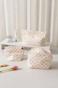 Détails de trois trousses de toilette à fleurs avec texture velours et zips dorés