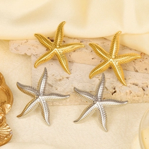Detailed shot of starfish earrings in gold and silver on natural stone and silk