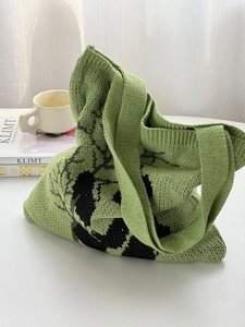 Artistic green knit tote bag with black panda pattern and woven shoulder strap