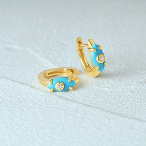 Macro shot of gold-plated evil eye hoop earrings with blue enamel and white zircon detail