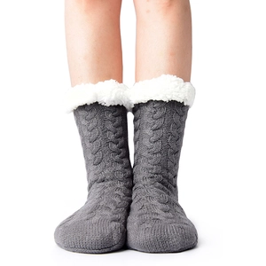 Deep grey cable knit slipper socks with white plush lining shown on a model