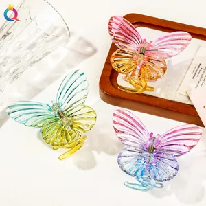 Macro detail of butterfly hair claws with gradient acrylic wings and metal spring