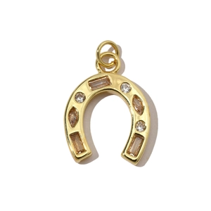 Macro shot of horseshoe pendant with gold plating and multicolor zircon stone inlays