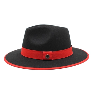 Detailed shot of a black wool fedora featuring a red ribbon band and gold metal M buckle