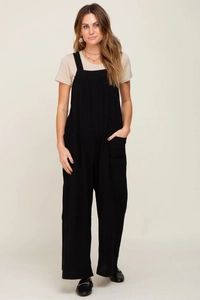 Detailed view of black maternity wide-leg overalls with beige short sleeve t-shirt