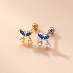 Close-up of gold and silver bow stud earrings with blue zircon and screw back