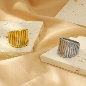 Close-up of hollow vertical striped gold and silver rings on elegant stone pedestals