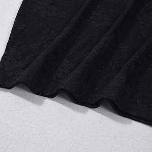 Detail of delicate black floral lace fabric with intricate mesh patterns and soft texture