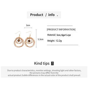 Macro detail of gold-tone geometric layered tiger eye stone earrings with dimensions