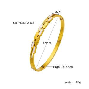 Detail view of a 6mm gold stainless steel bangle with white enamel and LOVE engraving