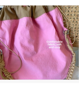 Dettaglio borsa con coulisse in nylon rosa e marrone con manico in corda intrecciata