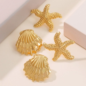 Macro shot of gold starfish and scallop stud earrings with detailed metallic textures