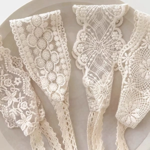Vue à plat de quatre bandeaux en dentelle blanche vintage pour bébés sur plat