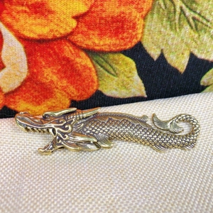 Vintage brass dragon-fish figurine with detailed scales and traditional antique finish