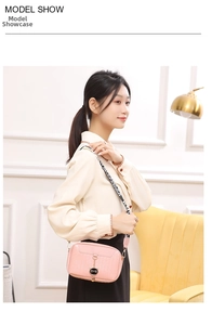 Chic pink embossed crossbody bag with cat pendant and lettered strap shown on a model