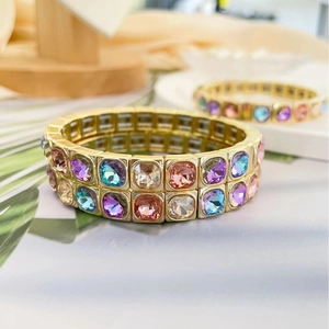 Elegant gold bracelet with colorful square crystals in purple, cyan and pink hues