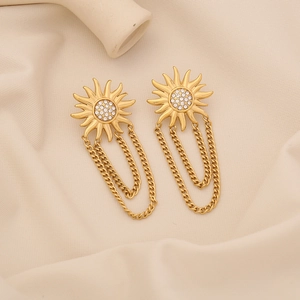 Golden sunflower tassel earrings with crystal flower core on beige fabric background