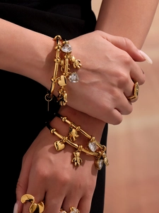 Close-up of gold-plated bracelets featuring 3D bear charms and heart-shaped crystals