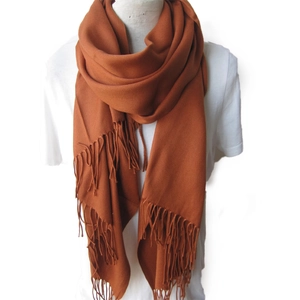 Écharpe unie orange-marron style cachemire avec franges sur mannequin fond blanc épuré