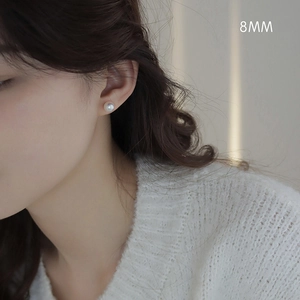 Close-up of 8mm classic white pearl stud earring on a model for casual daily wear