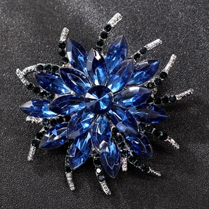 Detailed view of luxury radial flower brooch with blue crystals and silver-toned alloy