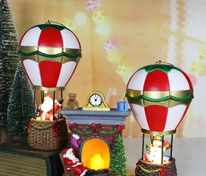 Detailed view of glowing Christmas resin fireplace with Santa and snowman air balloons