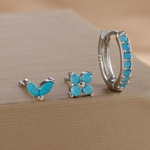 Macro detail of S925 silver jewelry set featuring turquoise floral studs and hoop