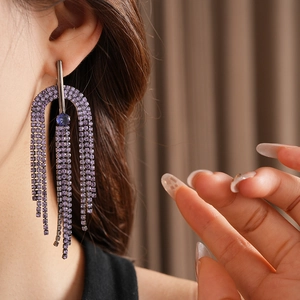 Detail of silver drop earrings with purple zircon tassels and geometric hollow frame