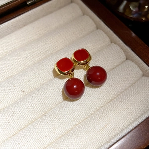 Macro shot of vintage tiger eye geometric earrings in a beige velvet wooden jewelry box