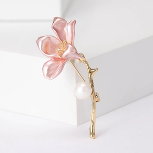 Close-up of pink morning glory flower brooch with golden stem and white pearl detail