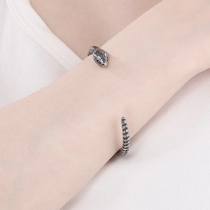 Detailed close-up of retro silver snake bracelet showing intricate scale textures on skin