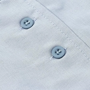 Gros plan sur la texture du tissu gris clair et les boutons assortis de la robe