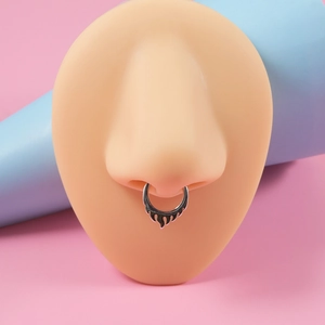 Silver stainless steel flame septum ring displayed on a realistic nose model