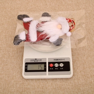 Detailed view of plush Santa Claus ornament on a digital scale weighing about 15 grams