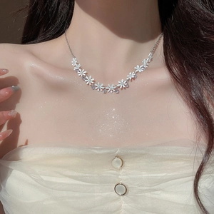 Detail of silver chain necklace with white pearl flower and sparkling clear crystals