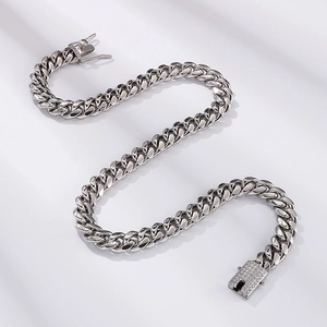 Detail of silver iced out Cuban link chain with sparkling stones on white background
