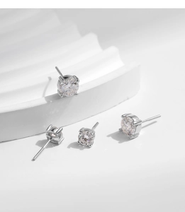 Detail of four-prong moissanite stud earrings showing screw-back posts on wave pedestals