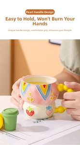 Detail of ceramic mugs featuring unique yellow beaded handles and hand-painted relief patterns