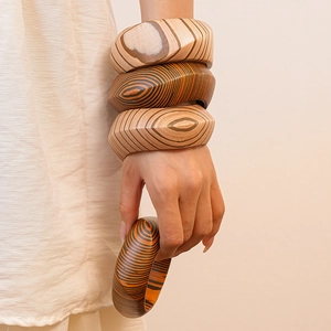 Close-up of stacked wooden bangles showing natural grain texture and artisan craftsmanship