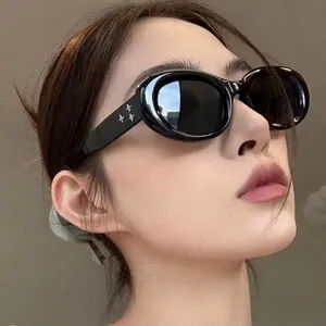 Oval black sunglasses with three star side metal accents and dark tinted lenses