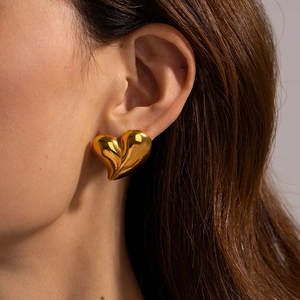 Exaggerated 18k gold plated smooth heart earrings on model with metallic luster
