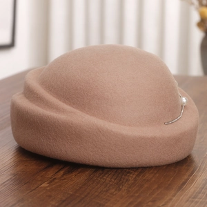 Détail d'un chapeau en laine camel orné de perles élégantes et de chaînes en strass