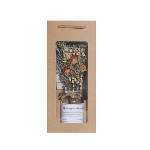 Dried flower bouquet in glass bottle within a kraft paper gift box for home decor