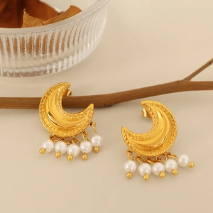 Elegante goldene Mondohrringe mit weißen Perlen-Quasten in stilvollem Lifestyle-Ambiente